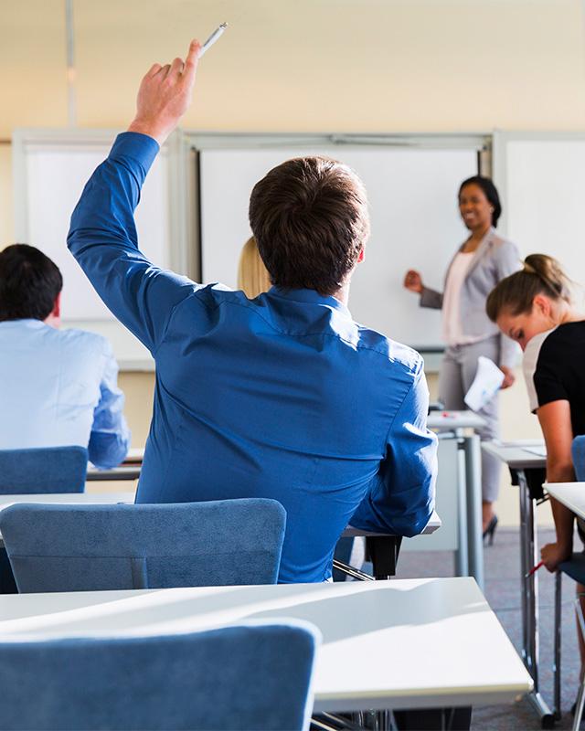 Business student raising hand in classroom